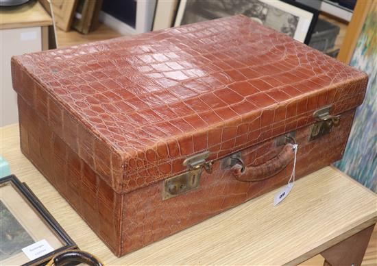 An Edwardian crocodile skin travelling toilet case, fitted with ivory accessories